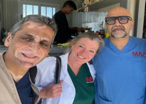 Amjid in his scrubs stood with two others people near a Lebanon hospital