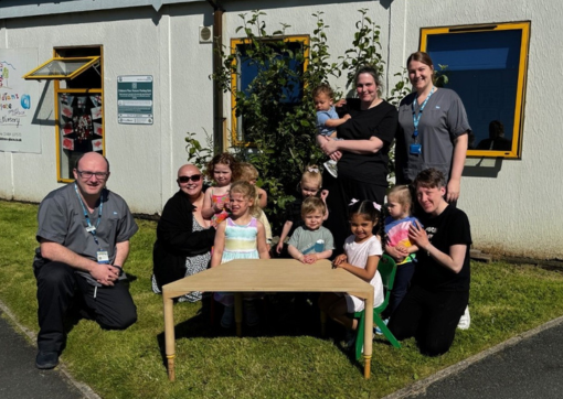 Some of the children and staff at Spring Cottage Nursery with a couple of staff members from audiology