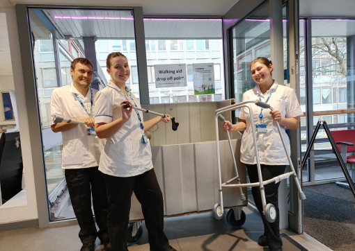 Rehab assistants Zach Watson, Megan Dyer and Alice Bradley in the main entrance at HRI next to the bin, holding walking frames 